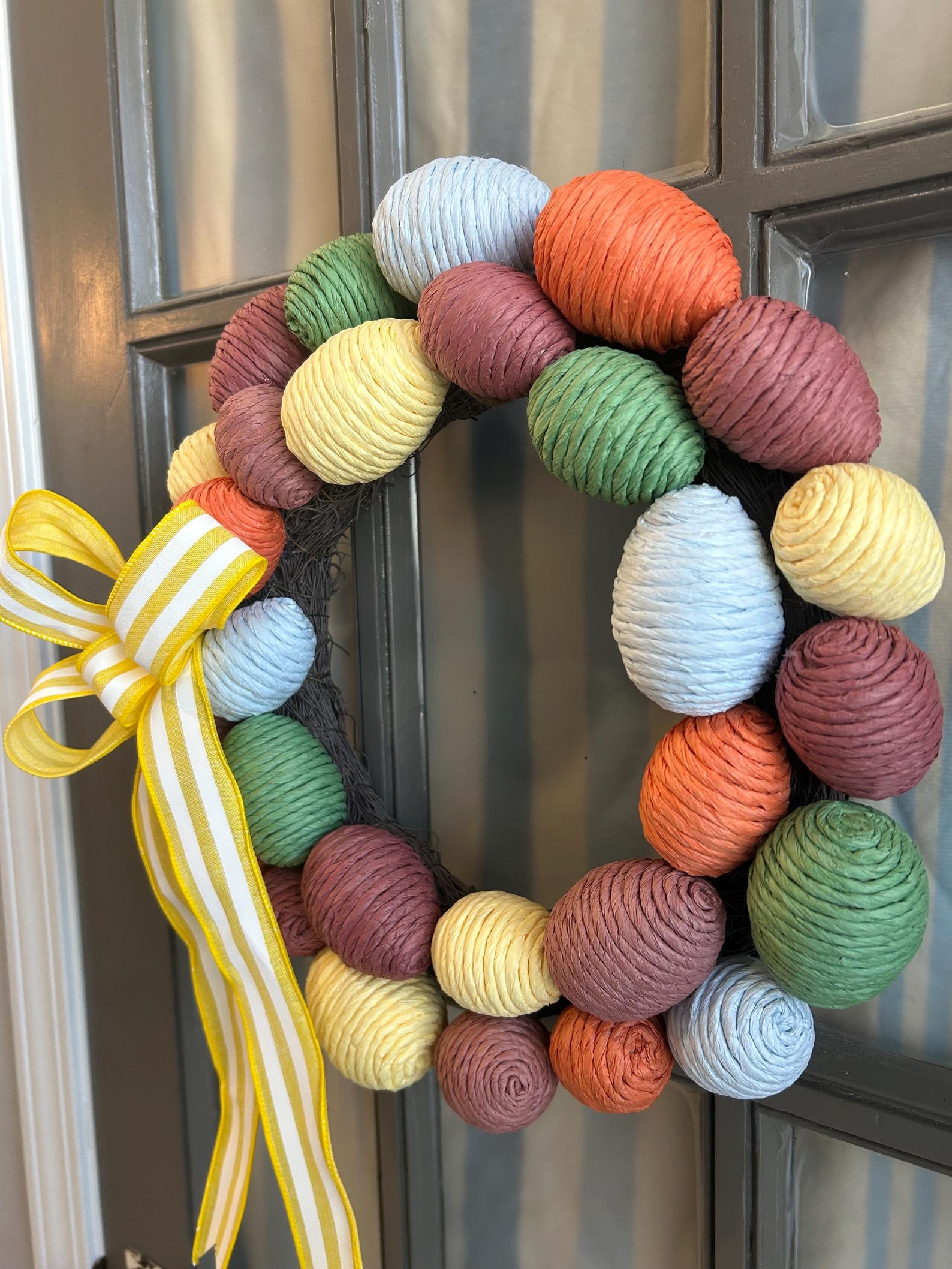 Multi Color Raffia Easter Egg Wreath With Yellow and White Striped Bow ...
