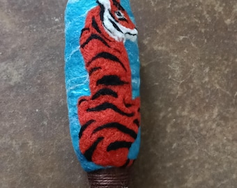 Sitting tiger on this needle felted wool drum beater with a driftwood handle.
