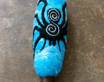 Spider waits. This is a needle felted wool drum beater with a driftwood handle.