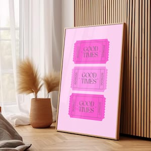 Könnte beinhalten: Rosa-weißes Poster mit drei rosafarbenen Tickets, auf denen "Good Times" steht. Die Tickets haben auf jeder Seite eine Nummer. Das Poster ist in einem goldenen Rahmen gerahmt.