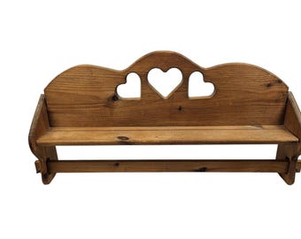 Estante rústico de madera con recortes de corazones para colgar en la pared.
