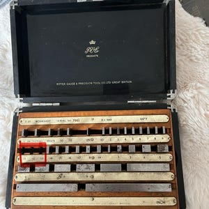 Könnte beinhalten: Eine offene schwarze Holzkiste mit Präzisionsmesswerkzeugen. Auf der Kiste steht "PITTER GAUGE & PRECISION TOOL CO., LTD. GREAT BRITAIN." Die Werkzeuge sind mit Zahlen und Maßen in Zoll beschriftet. Die Kiste trägt auch den Text "PVE PRODUCTS."