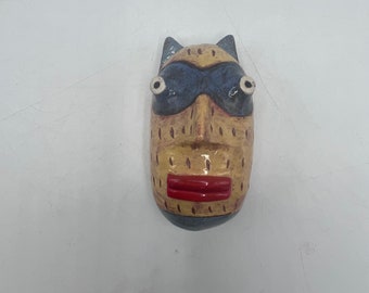 small round wall sculpture - yellow bandit cat