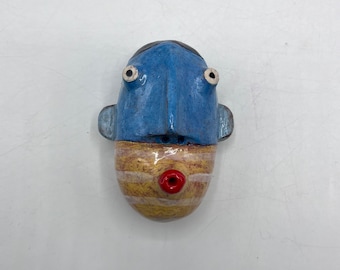 small round wall sculpture - blue person w/striped beard