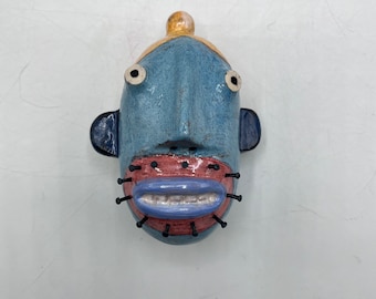 small round wall sculpture - blue person w/pink nail beard