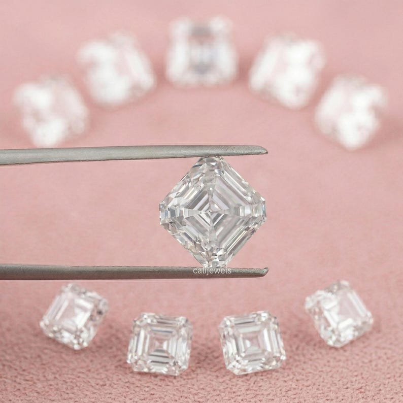 May include: A collection of Asscher cut diamonds, one held by tweezers, with others scattered on a pink surface. The diamonds are clear and reflect light, showcasing their intricate facets. The image is well-lit, highlighting the clarity and brilliance of the gemstones.
