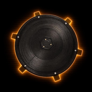 May include: A black, circular object with a textured surface and a glowing orange outline. The object has a central hexagonal design and several small, square protrusions around the edge, each with a glowing orange accent. Small silver screws are visible.