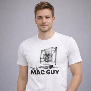 May include: White t-shirt with a black and white sketch of a computer monitor and keyboard. The text "I'm a MAC GUY" is printed below the graphic. The shirt is worn by a person.
