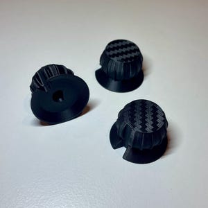 Radial dials on a fanatec mclaren GT3 V2 wheel. 3 black with carbon fibre accent