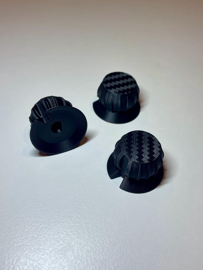 Radial dials on a fanatec mclaren GT3 V2 wheel. 3 black with carbon fibre accent