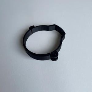 Sim racing cable management clamp for sim rig. Cable management organiser shown on a white desk