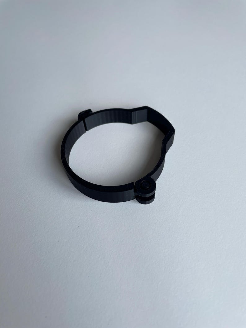 Sim racing cable management clamp for sim rig. Cable management organiser shown on a white desk