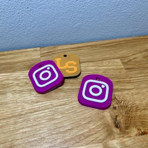 Square NFC tag showing branding on the front. Bright colours relating to the brand. Shown on a wooden desk with grey background
