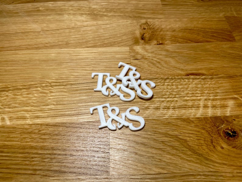 Drinks topper in white on a wooden desk. Initials T&S