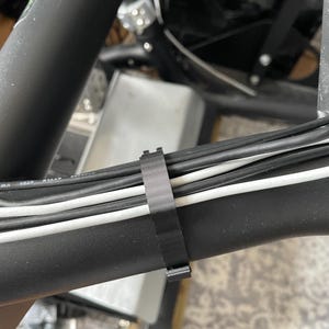 Sim racing cable management clamp for sim rig. Cable management organiser shown in use