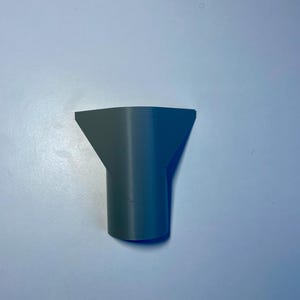 May include: A gray plastic nozzle with a wide opening at the top and a narrower opening at the bottom.