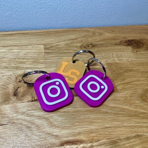 Square NFC tag showing branding on the front. Bright colours relating to the brand. Shown on a wooden desk with grey background