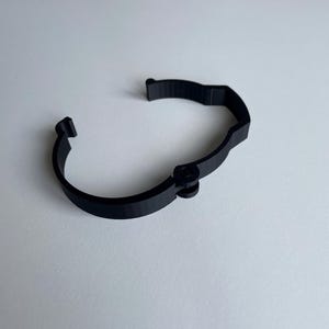 Sim racing cable management clamp for sim rig. Cable management organiser shown on a white desk