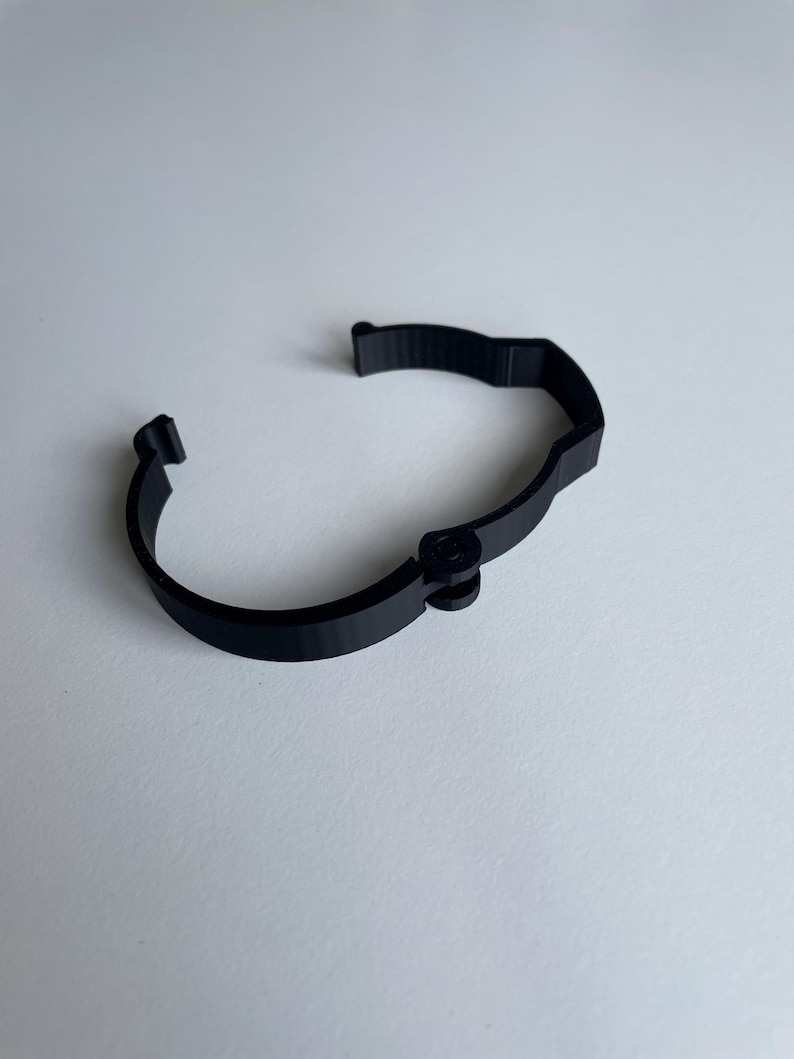 Sim racing cable management clamp for sim rig. Cable management organiser shown on a white desk