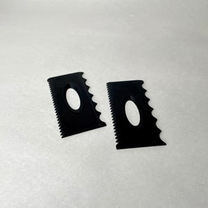 May include: Two black pottery rib tools with a serrated edge and an oval cutout. These tools are used for shaping and smoothing clay in pottery and ceramics.