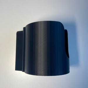 Cup holder for the trak racer TR8 in black on a white desk
