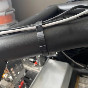 Sim racing cable management clamp for sim rig. Cable management organiser shown in use