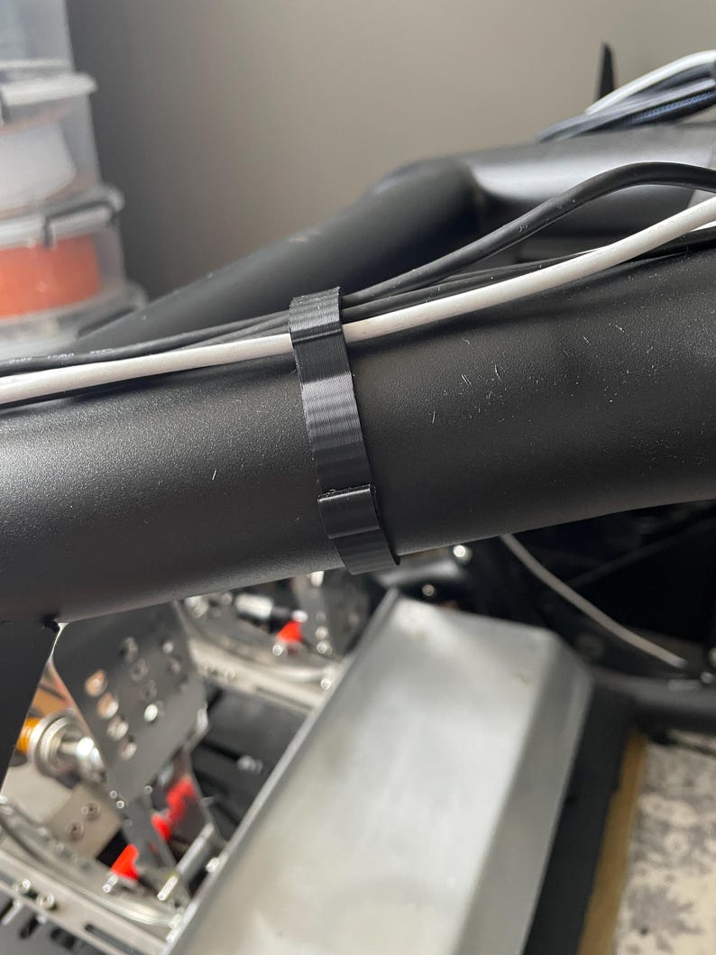 Sim racing cable management clamp for sim rig. Cable management organiser shown in use
