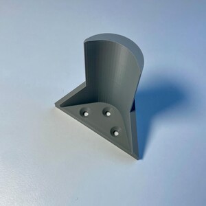 May include: A gray 3D printed corner shelf bracket with four screw holes.