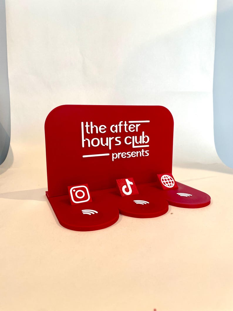 May include: A red display stand with the text "the after hours club presents" in white. The stand has three platforms with social media icons: Instagram, TikTok, and a globe.