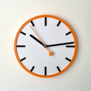 May include: A round orange clock with black hour and minute hands and black markings for the hours. The clock face is white.