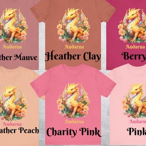 May include: Six different color t-shirts featuring a gold dragon with floral accents. The text "Andarna" is printed on each shirt. The colors are Heather Mauve, Heather Clay, Berry, Heather Peach, Charity Pink, and Pink.