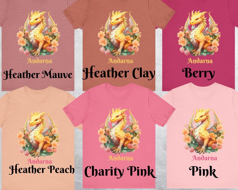 May include: Six different color t-shirts featuring a gold dragon with floral accents. The text "Andarna" is printed on each shirt. The colors are Heather Mauve, Heather Clay, Berry, Heather Peach, Charity Pink, and Pink.