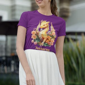 May include: Purple t-shirt with a yellow dragon and floral design. The text "Andarna" is printed on the shirt.