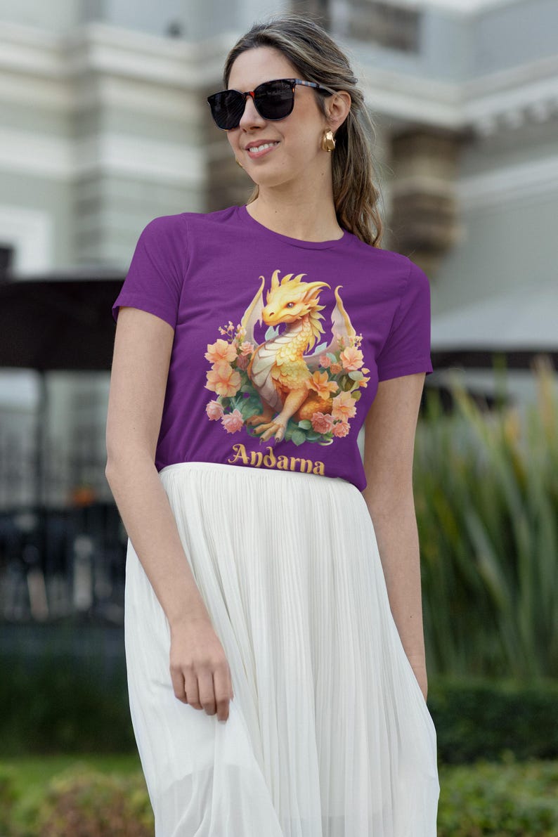 May include: Purple t-shirt with a yellow dragon and floral design. The text "Andarna" is printed on the shirt.