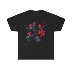 Puede incluir: Camiseta negra con un diseño de ninja. La imagen muestra un ninja en una pose dinámica, con caracteres japoneses rojos y estrellas. El ninja está vestido de negro, con capucha y cubrecara. El diseño tiene un estilo gráfico y audaz.