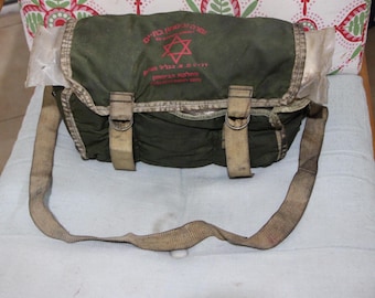 May include: A green canvas messenger bag with a tan strap and a red Star of David logo. The logo reads "צה"ל" in Hebrew, which translates to "IDF" (Israel Defense Forces).