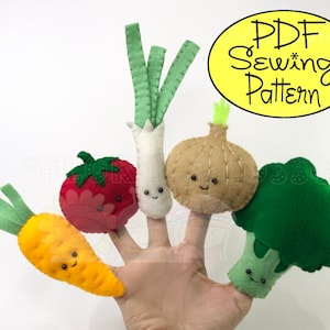 May include: A set of five felt finger puppets shaped like vegetables: a green onion, a red tomato, a brown onion, a green broccoli, and an orange carrot. Each puppet has a smiling face. The puppets are arranged on a hand, with the green onion on the index finger, the tomato on the middle finger, the brown onion on the ring finger, the broccoli on the pinky finger, and the carrot on the thumb. The text "PDF Sewing Pattern" is in a yellow oval in the upper right corner of the image.