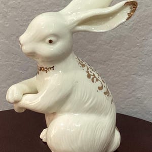 Porcelain Bunny rabbit by "Formalities, Baum" cream with gold details, little necklace with blue, red, green and red jewels. 6.25 x 3".