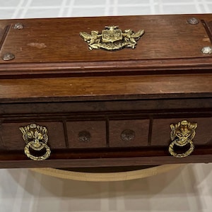 Vintage S. Super Bijou wooden jewelry box with a hinged lid and brass coat of arms design on top  dimensions approximately 10”x6”x4”