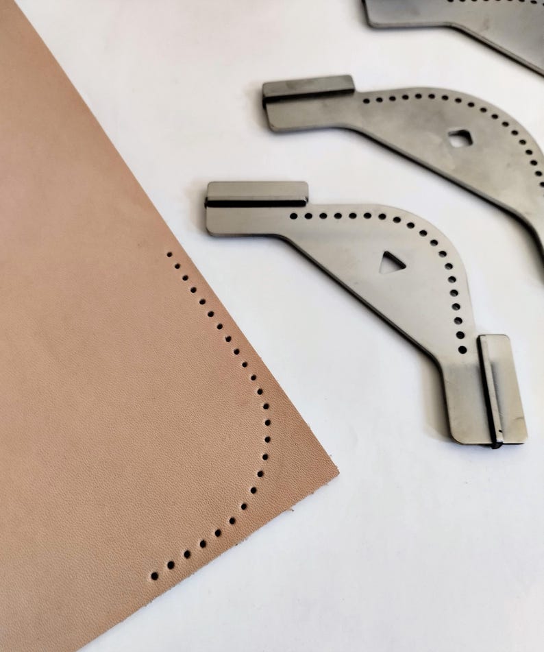 Peut inclure: Gros plan sur un morceau de cuir beige avec un bord incurv&eacute;, ponctu&eacute; de trous espac&eacute;s. Trois outils de maroquinerie en m&eacute;tal sont positionn&eacute;s &agrave; proximit&eacute;. Les outils ont un design incurv&eacute; avec une s&eacute;rie de trous et une extr&eacute;mit&eacute; rectangulaire.
