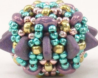 May include: Two beaded spheres with a spiky, geometric design. One sphere is purple, teal, and gold, while the other is black, copper, and gold.