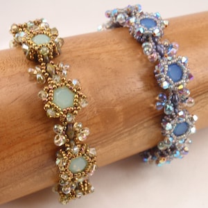 Puede incluir: Dos pulseras de cuentas con un diseño de estrella. Una pulsera tiene piedras de color azul claro y la otra tiene piedras de color verde claro.