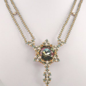 Könnte beinhalten: Eine Halskette mit Perlen und einem sternförmigen Anhänger mit einem großen, schillernden Edelstein. Die Halskette hat ein doppelreihiges Design mit goldenen und silbernen Perlen und einen tropfenförmigen Perlenanhänger.