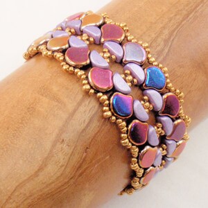 May include: A multi-strand bracelet made with iridescent purple, pink, and blue beads, interspersed with gold seed beads.