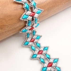 May include: A turquoise and red beaded bracelet with a silver finish. The bracelet is made with small, faceted beads and has a geometric pattern.