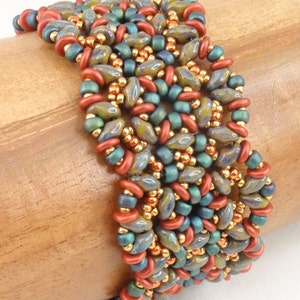 May include: A beaded bracelet with a woven pattern in shades of teal, gold, and copper.