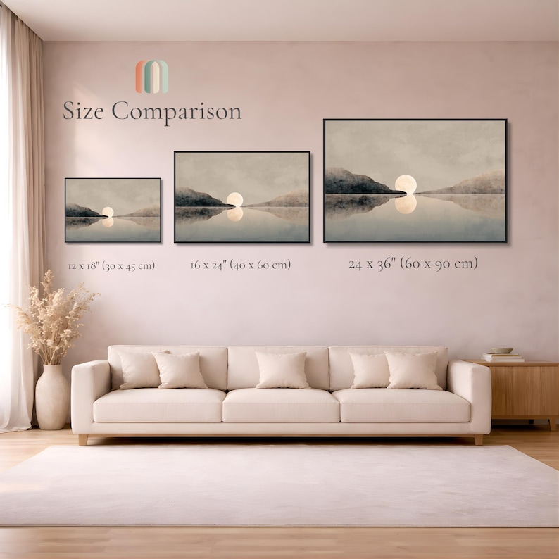 May include: Three framed landscape prints showing a sunset over water with mountains, labeled Size Comparison. Sizes are 12 x 18 inches, 16 x 24 inches, and 24 x 36 inches. The prints are displayed on a wall above a beige sofa in a room.