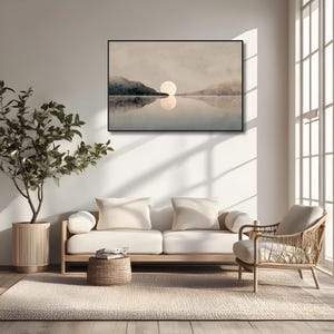May include: A rectangular wall art print featuring a landscape with a large, pale moon centered above a calm body of water. Dark, silhouetted mountains flank the horizon, with the moon's reflection visible on the water's surface in a muted palette.