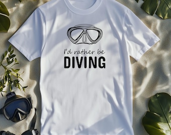 Puede incluir: Camiseta blanca con un gráfico de máscara de buceo negro y el texto "I'd rather be DIVING".