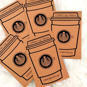 May include: A collection of brown coffee cup sleeves with a black coffee cup design and the text "Coffee Cup Sleeve". Each sleeve features a coffee art design and the words "Handmade With Love".